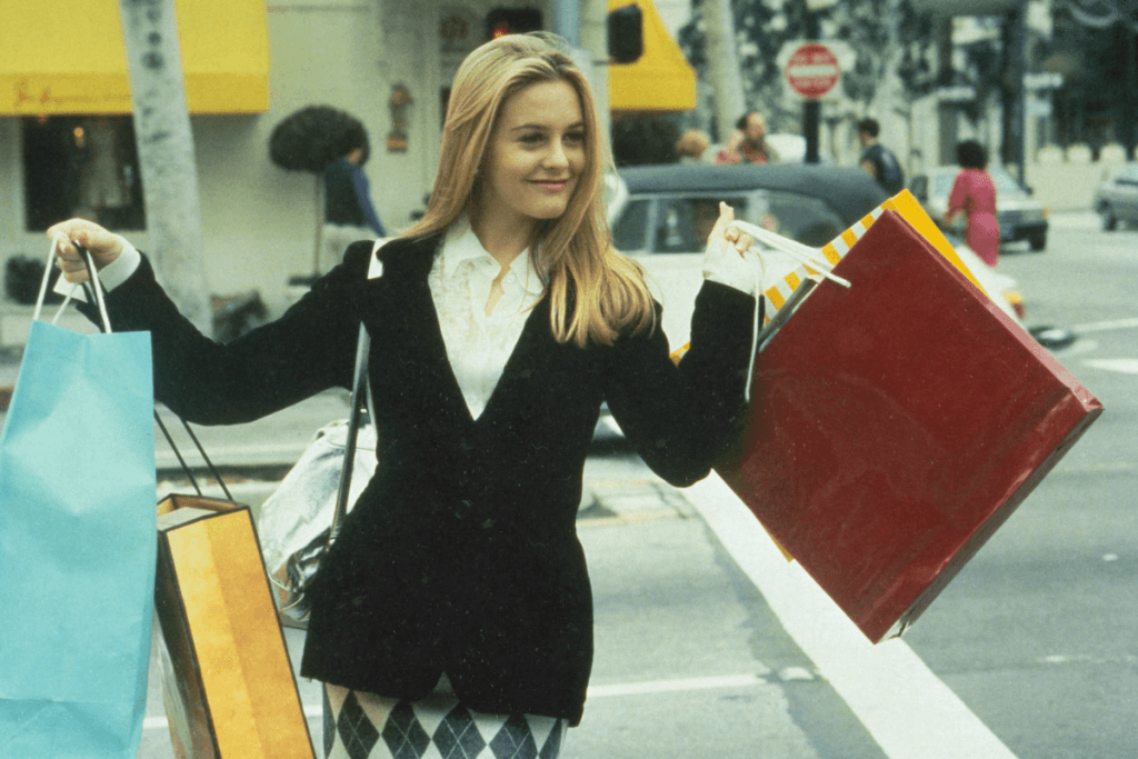 5 Types of E-Commerce: The Essential Guide for Online Success Woman holding a bunch of shopping bags in both her hands, walking down the street, looking happy.