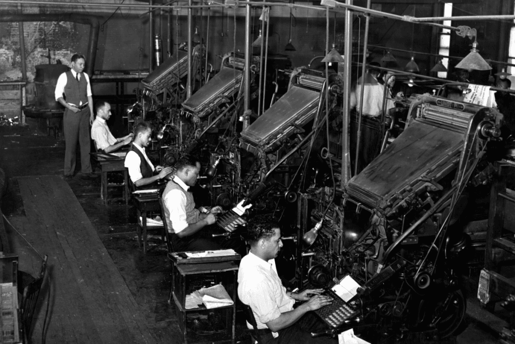 AI In Typography: The Human Perspective A black and white photo of workers in an assembly line writing on their typewriters, with one man overseeing the operations.
